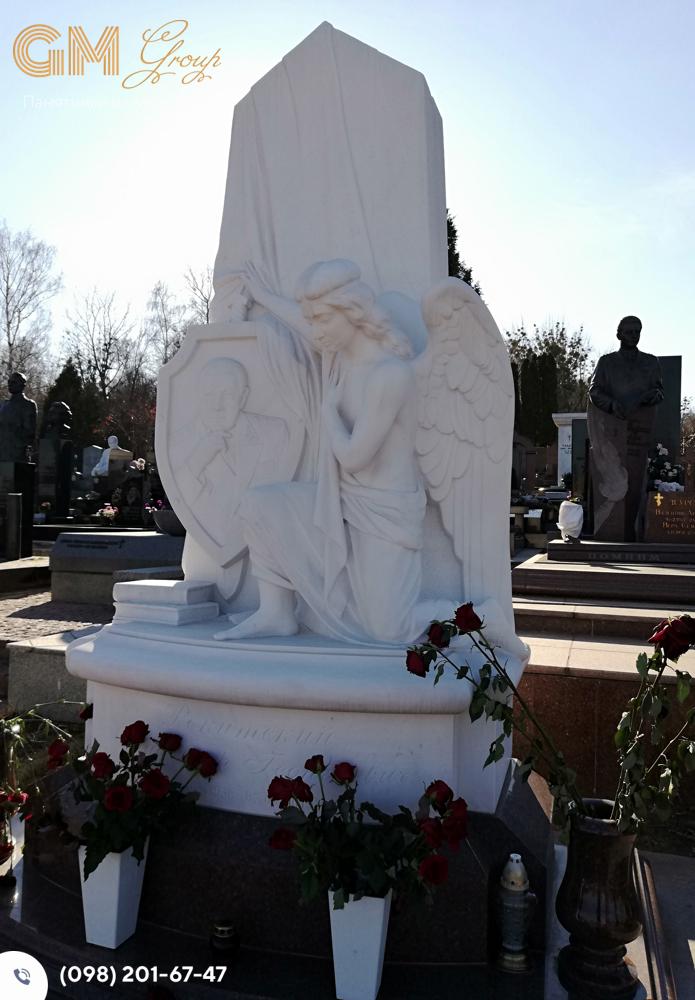 памятник мужчине со скульптурой ангела